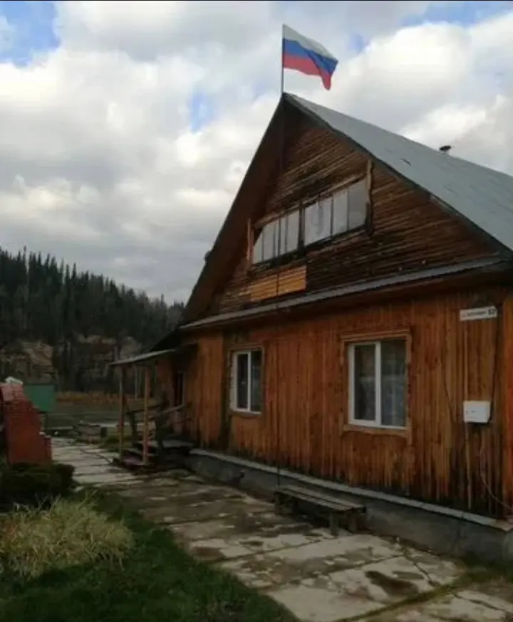 Деревянный гостевой дом на фоне лесистого склона
